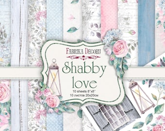 May include: A pack of 10 sheets of decorative paper with a shabby chic theme. The paper features a variety of floral patterns, including roses, hydrangeas, and leaves. The paper is printed on a white background with a subtle texture. The pack also includes a sheet of stickers with a vintage window and lanterns. The paper measures 8 inches by 8 inches. "Fabrika Decoru Shabby Love 10 sheets 8"x8" 10 листов 20x20cm" is printed on the front of the pack.
