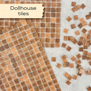 May include: Brown and beige square tiles for dollhouses. The tiles are arranged in a grid pattern and are scattered on a light grey surface. The text "Dollhouse tiles" is written on a light brown rectangle.