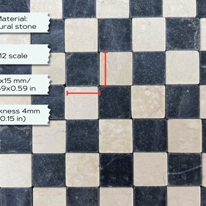 Może przedstawiać: Mozaika z płytek z naturalnego kamienia ułożonych w szachownicę. Każda płytka ma wymiary 15 mm x 15 mm i grubość 4 mm. Płytki są ułożone w czarno-biały wz&oacute;r szachownicy.