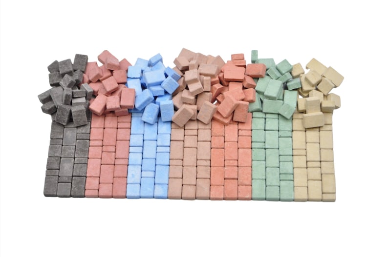 May include: Assortment of small, square mosaic tiles in six colors: gray, red, blue, brown, green, and beige. The tiles are arranged in rows, with each color in a separate row.