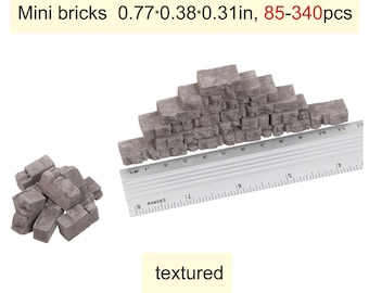 Könnte beinhalten: Miniatur-Grausteine mit Textur, jeweils ca. 1,96 x 0,97 x 0,79 cm groß. Das Bild zeigt einen Haufen Steine und eine damit gebaute Struktur, zusammen mit einem Lineal zur Maßstabsbestimmung. Der Text "textured" ist ebenfalls vorhanden.