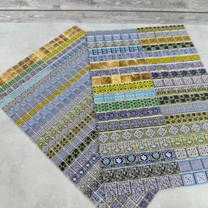 Puede incluir: Un conjunto de azulejos decorativos con intrincados patrones en tonos de azul, verde, dorado y blanco. Los azulejos están dispuestos en un patrón de cuadrícula y presentan una variedad de diseños geométricos y florales.