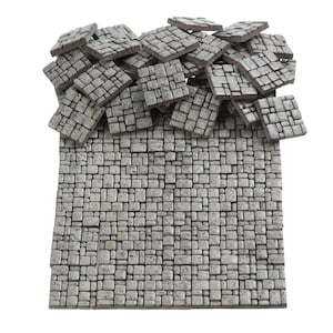 Puede incluir: Una pila de azulejos de piedra gris, algunos apilados uno encima del otro, con una sección más grande de los mismos azulejos dispuestos en un patrón plano y rectangular.