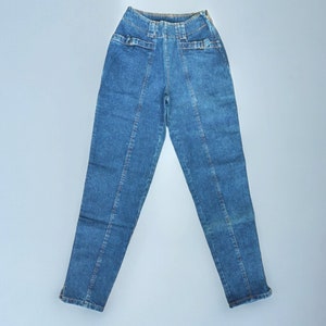 Könnte beinhalten: Eine blaue Jeanshose mit hoher Taille und geraden Beinen. Die Jeans hat einen Knopfverschluss und Gürtelschlaufen.