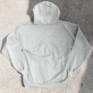 May include: A gray hooded sweatshirt with long sleeves and a pouch pocket.