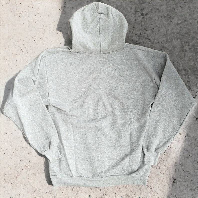 May include: A gray hooded sweatshirt with long sleeves and a pouch pocket.