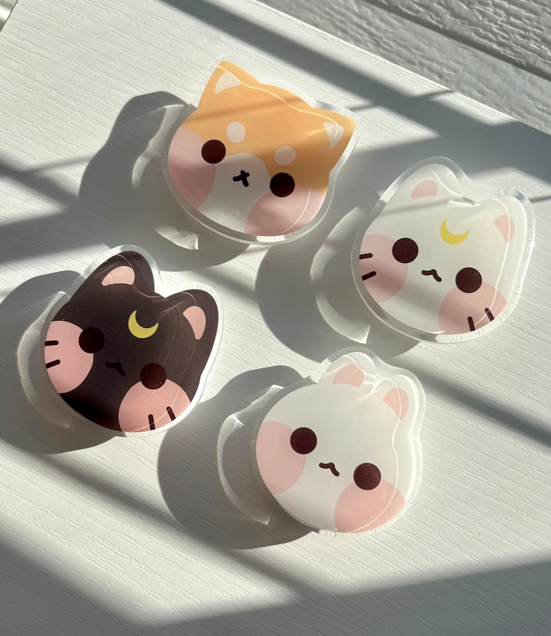 May include: Four colourful cartoon animal stickers with a crescent moon design. The stickers are on a white surface.