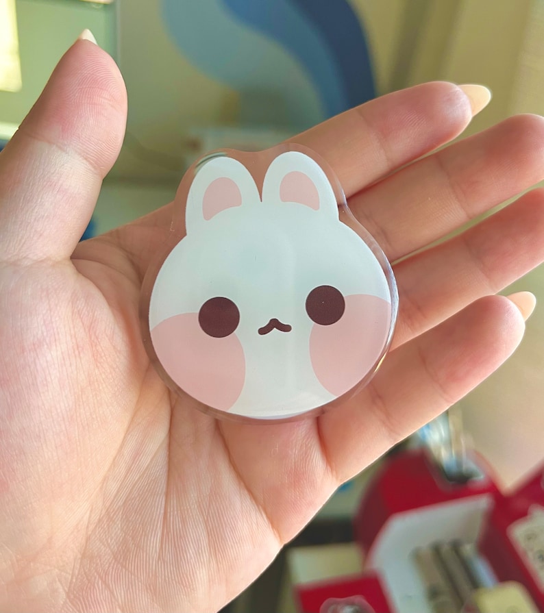 May include: A white and pink resin bunny charm with a cute cartoon face. The charm has large, round eyes and a small, pink nose.