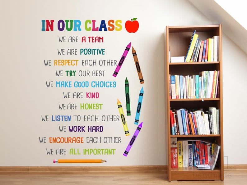 Pode incluir: Decora&ccedil;&atilde;o de parede para sala de aula com um design de l&aacute;pis de cor e o texto "In Our Class" seguido de uma lista de valores positivos para a sala de aula. Os valores incluem: Somos uma equipe, Somos positivos, Respeitamos uns aos outros, Fazemos o nosso melhor, Fazemos boas escolhas, Somos gentis, Somos honestos, Ouvimos uns aos outros, Trabalhamos duro, Incentivamos uns aos outros, Todos somos importantes.