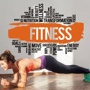 May include: A woman in a pink and black workout outfit is performing a plank exercise. The background wall features a large orange and white word cloud with the word "FITNESS" in the centre. The word cloud includes words such as "goals", "active", "move", "success", "healthy", "power", "marathon", "energy", "resolution", and "sport".