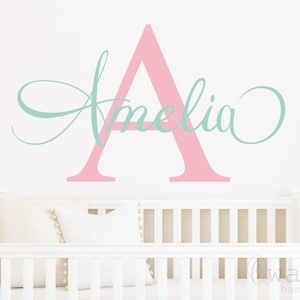 Può includere: Adesivo da parete in vinile rosa e azzurro chiaro con il nome Amelia e la lettera A in un carattere corsivo.