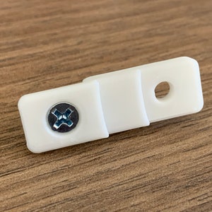 Puede incluir: Soporte de barra de cortina de pl&aacute;stico blanco con un tornillo y un agujero para montaje.