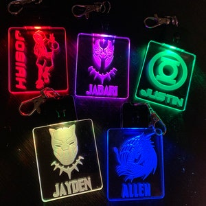 May include: Five light-up keychains with different designs and names. The keychains are red, purple, green, white, and blue. The names on the keychains are Josiah, Jabari, Justin, Jayden, and Allen.