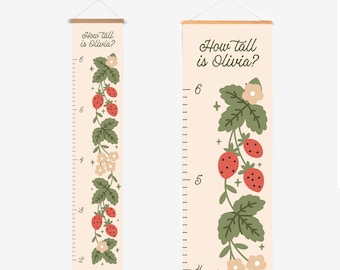 Puede incluir: Un medidor de altura beige con el texto "How tall is Olivia?" presenta un diseño de vid de fresas. El medidor mide hasta 183 cm y está adornado con fresas rojas, hojas verdes y flores color crema.