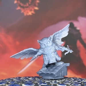 May include: A gray owl figurine with outstretched wings, holding a crossbow and a sword. The owl is perched on a tiled roof, set against a fiery red and orange background. The figurine is a fantasy-themed collectible.