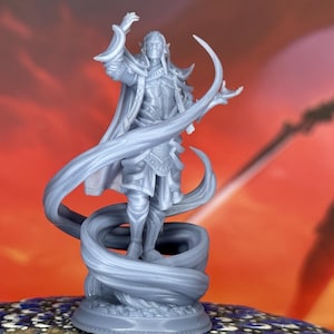 Puede incluir: Figura gris de fantasía de un personaje vestido con una túnica, con orejas puntiagudas, brazos levantados y cintas que fluyen. La figura se encuentra sobre una base circular. El fondo es naranja y rojo borroso.