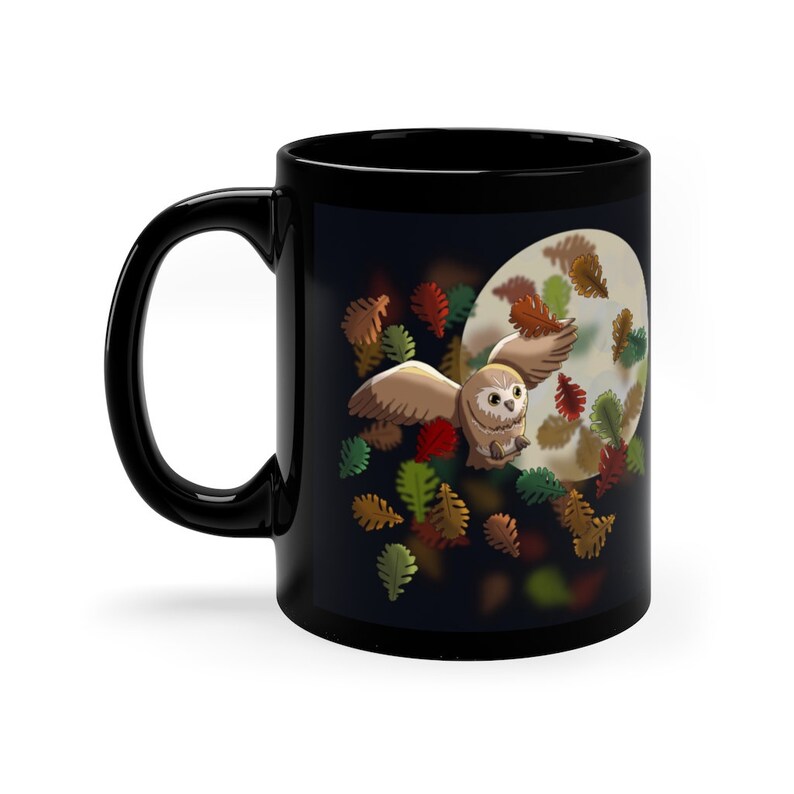 Pu&ograve; includere: Tazza in ceramica nera con un design di un gufo che vola davanti a una luna piena con foglie autunnali che cadono.