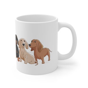 May include: White ceramic coffee mug with a design of four dachshund dogs in different colors. The dogs are facing the left side of the mug.