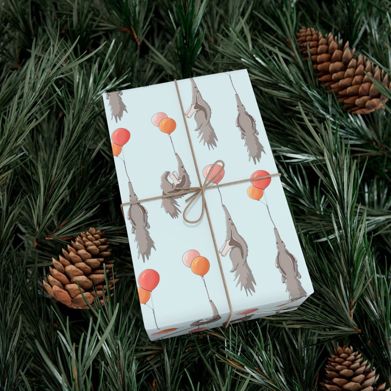 Pale blue gift wrap with illustrations of cute floating anteaters holding balloon strings with their tongues.