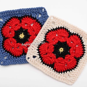 May include: Two crocheted squares with a floral design. One square is blue with a red, black, and yellow flower. The other square is off-white with a similar red, black, and yellow flower. The squares are handmade and feature a textured stitch.