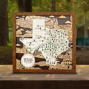 May include: A wooden framed Texas State Parks travel map. The map is a detailed laser-cut design with a brown frame. The map features the state outline, park locations, and the text "Texas State Parks Travel Map" in a circular emblem.