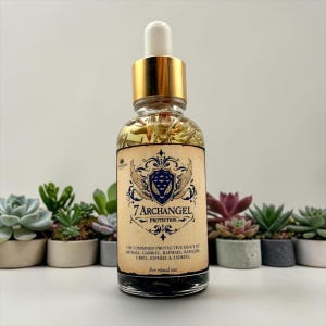 May include: A clear glass dropper bottle with a gold cap containing liquid and botanical elements. The label features a blue crest, the text 7 ARCHANGEL PROTECTION, and the names of seven archangels. The bottle is filled with oil and herbs.