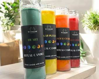 May include: Four glass ritual candles in shades of green, yellow, orange, and red. Each candle has a black label with the text "WINSLOW" and "RITUAL CANDLE". The labels also include the words "HEART", "SOLAR PLEXUS", "SACRAL CHAKRA", and "ROOT CHAKRA".