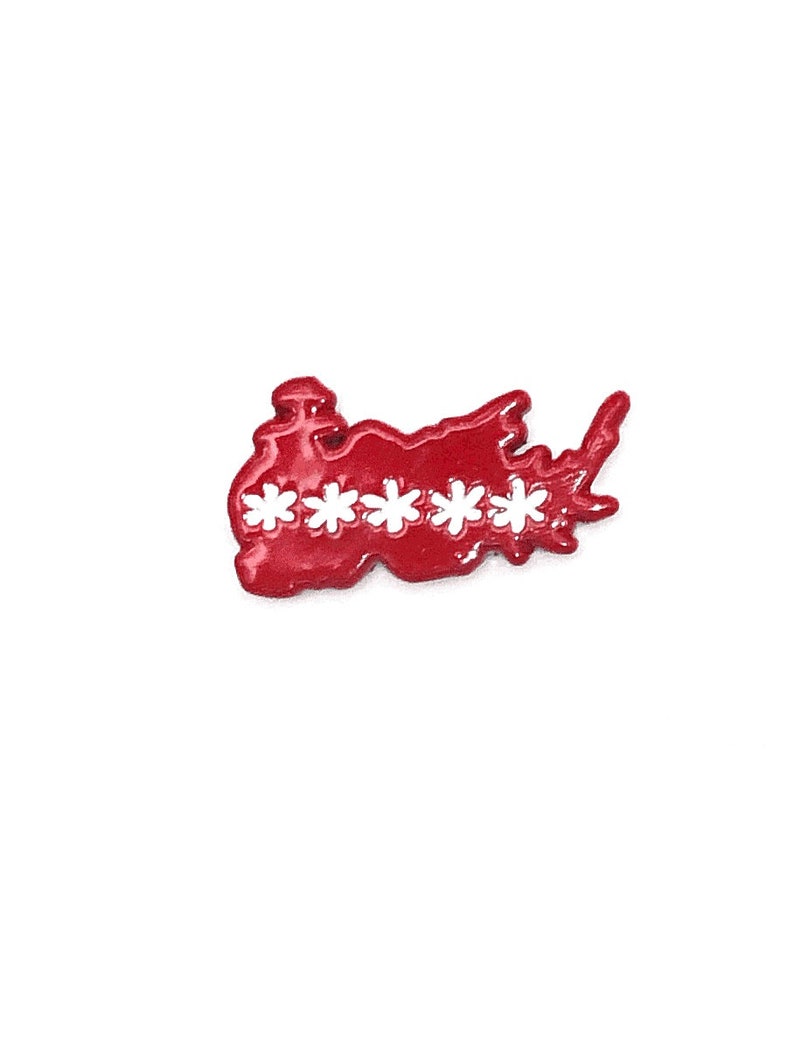 May include: A red enamel pin in the shape of a stylized map with five white flower-shaped cutouts. The pin has a glossy finish and is set against a white background.