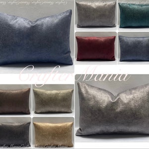 Puede incluir: Una colección de cojines decorativos de terciopelo en varios colores, incluyendo azul marino, burdeos y gris. Los cojines tienen una apariencia suave y afelpada y están dispuestos sobre una superficie clara. El texto "Crafter Mania" es visible.
