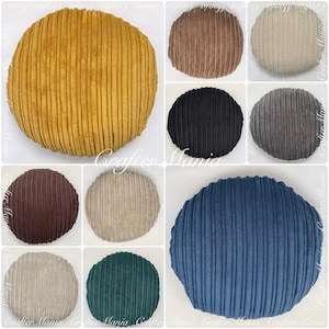 May include: Ten round, corduroy cushion pads in a variety of colours, including mustard yellow, brown, beige, black, grey, teal, and blue.