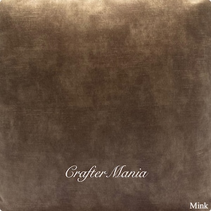May include: A close-up of a brown fabric with a subtle textured pattern. The fabric has a slightly metallic sheen and is labeled "Crafter Mania" and "Mink".