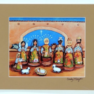 May include: A colorful illustration of a nativity scene with figures of angels, the three wise men, and baby Jesus. The artwork features a star, sheep, and a donkey, all set against a desert backdrop. Signed "Candy Mayor".