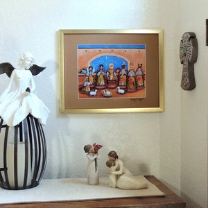 May include: A framed print of a Nativity scene with a gold frame hangs on a wall. A white angel statue with black wings sits atop a black and white metal lantern. Two small figurines and a decorative cross are also visible.