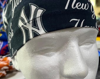 May include: A navy blue cap featuring the New York Yankees logo and script. The cap is made of fabric and is designed to be worn on the head. The words "New York Yankees" are visible on the cap.