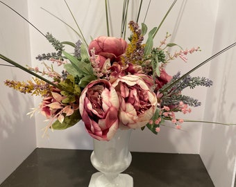 White glass vase with pink peonies and greenery inside