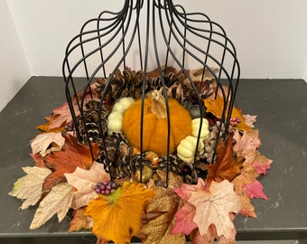 Black wrought iron birdcage with pumpkin decor