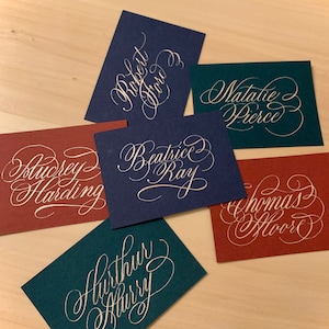 Tarjetas de lugar para bodas: escritas a mano en azul marino, verde azulado y borgoña
