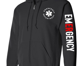 Könnte beinhalten: Schwarzer Kapuzenpullover mit Reißverschluss, mit einem weißen Lebensstern und den Worten "Emergency Department" auf der Vorderseite und dem Wort "EMERGENCY" in Rot und Weiß auf dem rechten Ärmel.
