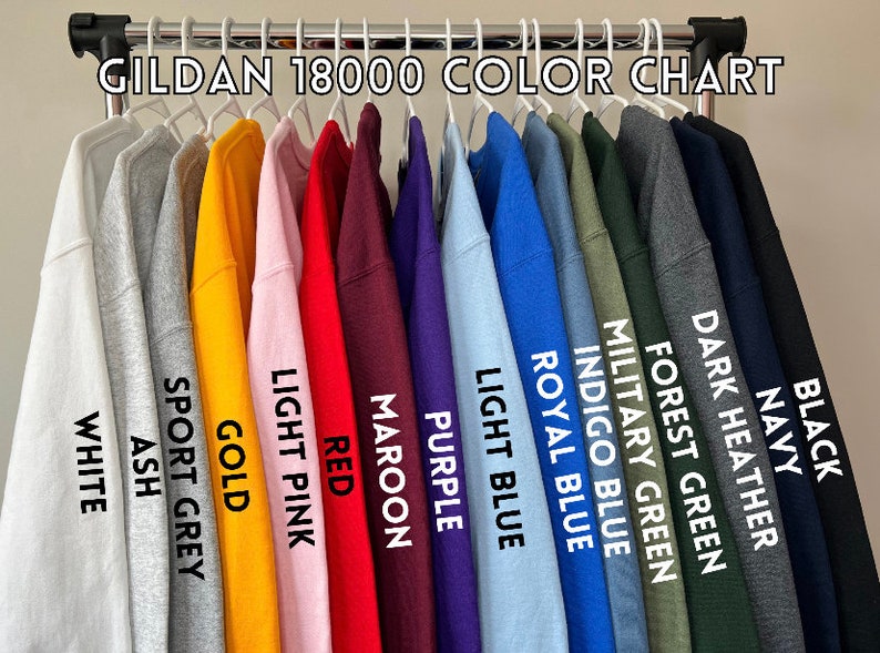 May include: Color chart for Gildan 18000 sweatshirts, showing 14 different colors: black, navy, dark heather, forest green, military green, indigo blue, royal blue, light blue, purple, maroon, red, light pink, gold, sport grey, ash, and white.
