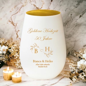 Könnte beinhalten: Weiße Vase mit goldfarbenem Rand und goldfarbener Beschriftung. Die Vase trägt die Aufschrift "Goldene Hochzeit 50 Jahre" mit einem floralen Design und den Initialen "B" und "H" mit einem Herz dazwischen. Die Vase trägt außerdem die Aufschrift "Bianca & Heiko" und "Alles Liebe wünscht Familie Koch".