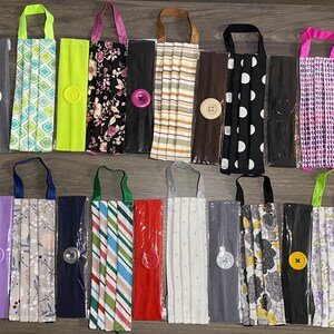 May include: A collection of 20 handmade face masks with matching headbands. The masks are made from various fabrics with different patterns, including floral, geometric, and polka dots. Each mask has a button on the side for easy adjustment.