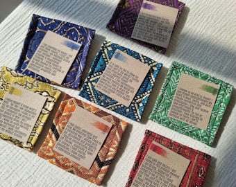 May include: An assortment of colorful, square fabric pouches with printed cards. The pouches feature intricate patterns in shades of blue, purple, green, yellow, and orange. Each card has text and a colored stripe.