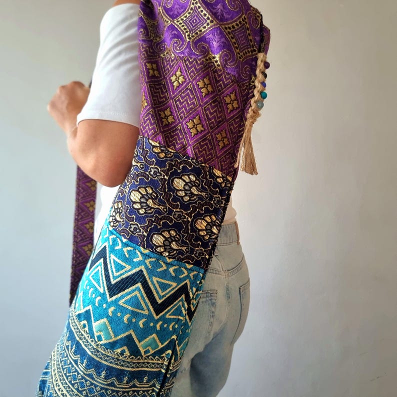 May include: A purple, blue, and gold yoga mat bag with a tassel. The bag is made of a patchwork of different fabrics with geometric patterns.