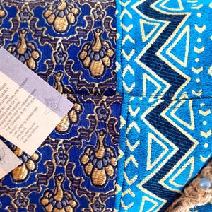 May include: A blue and gold patterned fabric pouch with a brown cord and blue and green stones. The pouch has two tags attached with the text "Third Eye" and "I can manifest my vision, I see and think clearly, I trust my intuition, I am mentally strong and resilient, I embrace creative and imaginative thinking, I allow myself to dream beyond the confines of my physical reality, I am open to inspiration and beauty, I am observant and perceptive."