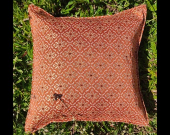 May include: A brown and white patterned throw pillow with a square shape. The pillow is made of a soft, textured fabric and has a subtle sheen.