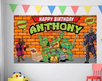 May include: A colorful birthday banner featuring the Teenage Mutant Ninja Turtles, Shredder, and Splinter against a brick wall backdrop. The banner reads "Happy Birthday Anthony" in large green letters. Colorful triangle flags are strung across the top.