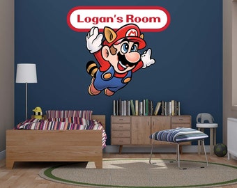 May include: A blue wall with a red and white banner that says "Logan's Room". A cartoon character of Mario from the Super Mario Bros. video game series is flying in the air. The character is wearing a red hat and overalls. There is a wooden bed with a striped blanket and a lamp on the left side of the image. There is a wooden cabinet with books on the top shelf and a striped ottoman in front of the cabinet.