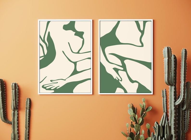 Op de afbeelding: Twee ingelijste abstracte kunstprints met een cr&egrave;mekleurige achtergrond en groene lijntekeningen van twee figuren in een liggende houding.