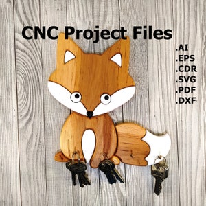 May include: Wooden fox key holder with a white belly and tail tip. The fox is sitting on a wooden surface and has five key hooks. The text "CNC Project Files" is at the top of the image. The file types available are listed below the text: .AI, .EPS, .CDR, .SVG, .PDF, .DXF.
