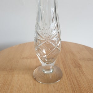 Puede incluir: Un jarr&oacute;n de cristal transparente para un solo bot&oacute;n, con un dise&ntilde;o de cristal tallado. El jarr&oacute;n tiene una base ancha y un cuello estrecho.